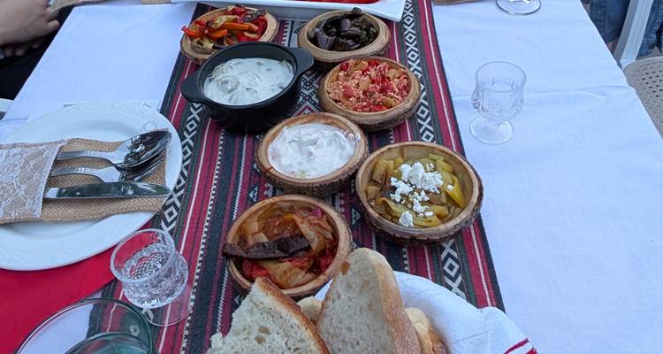 Plats albanais traditionnels servis sur une nappe à motifs.