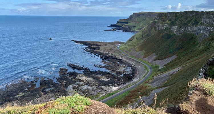 Kustrotsen en uitzicht op de oceaan met een kronkelende weg.