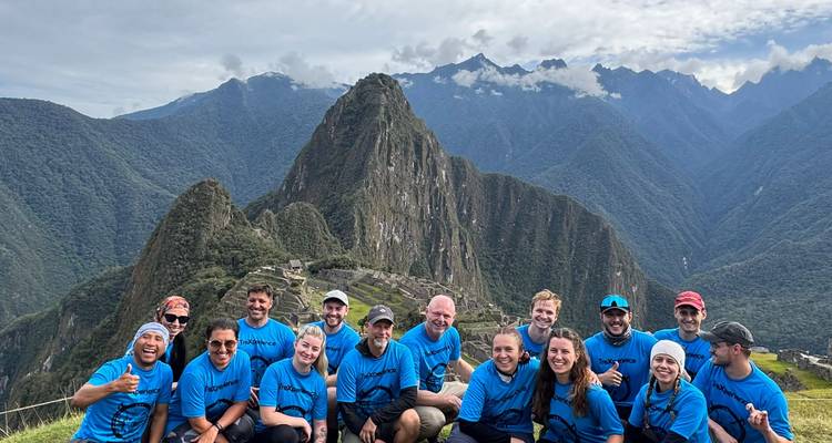 Groupe de touristes portant des t-shirts assortis devant le Machu Picchu.