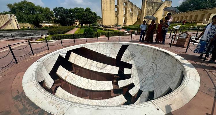 Touristes autour d'une grande structure de cadran solaire.