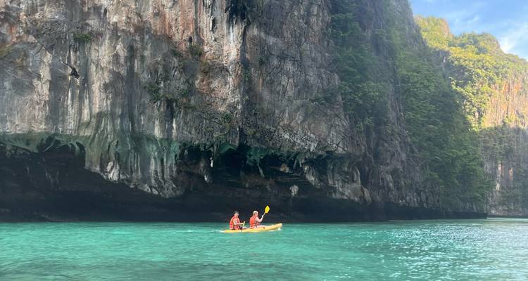 Pareja navegando en kayak cerca de acantilados de piedra caliza.