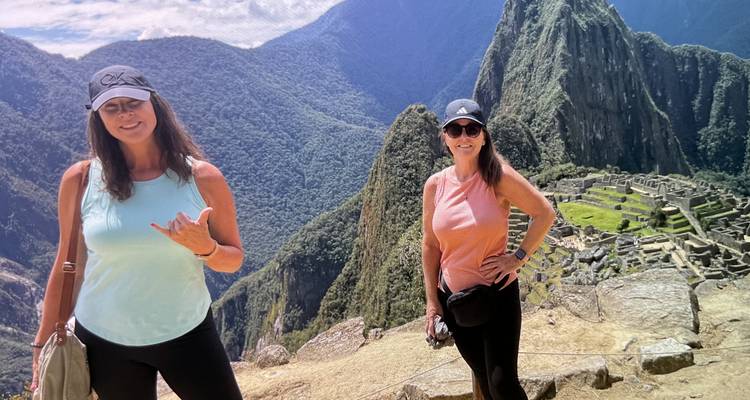 Deux femmes souriantes avec le Machu Picchu en arrière-plan.