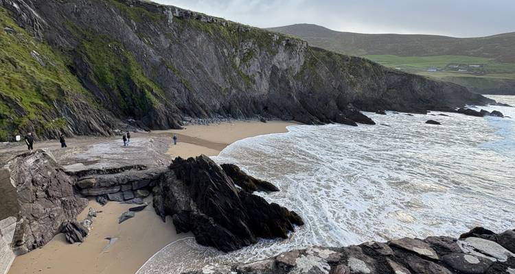A scenic coastal landscape with cliffs and a sandy beach.