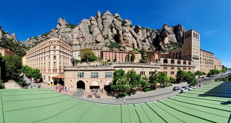 Un complexe monastique se dresse contre un décor de montagnes escarpées.