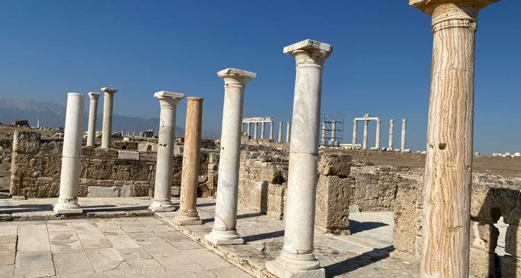 Ancient ruins with stone columns under a clear blue sky.