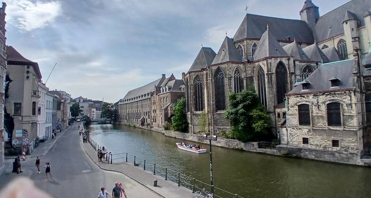 Un canal avec un bateau à côté d'une église de style gothique.
