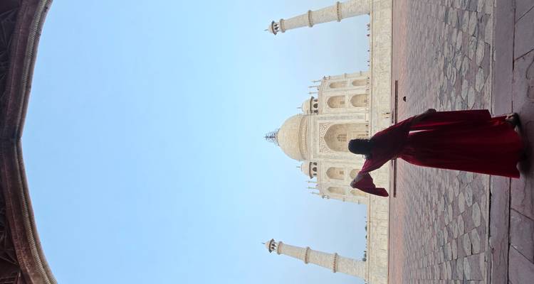 Silhouette of a person dancing in front of the Taj Mahal archway.