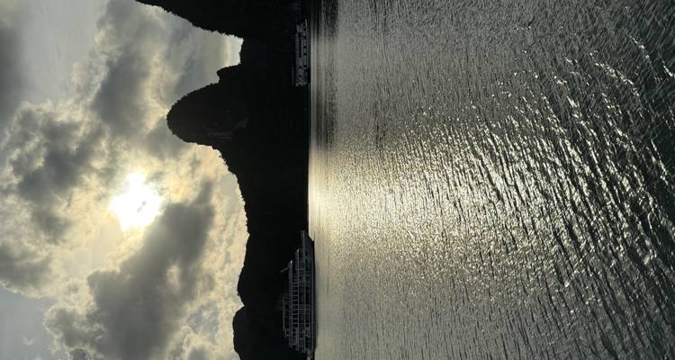 Sunset view of Halong Bay with silhouetted islands.