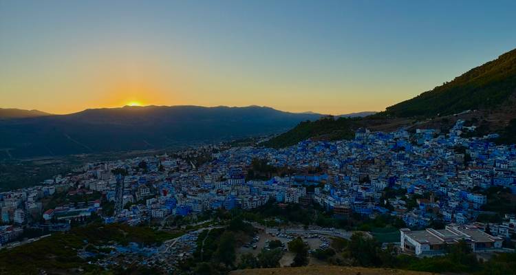 Vista desde la colina de una ciudad azul durante el atardecer.