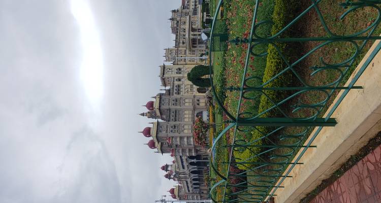 Mysore Palace with well-maintained gardens and ornate architecture.