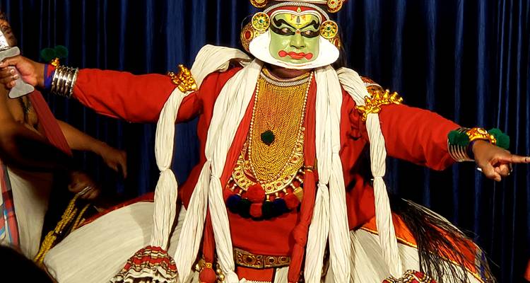 A traditional Kathakali dancer in full costume with expressive makeup.