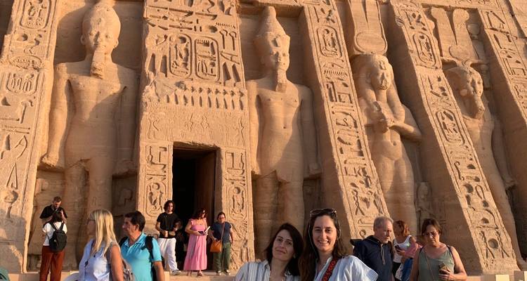 Group of people in front of rock carvings.