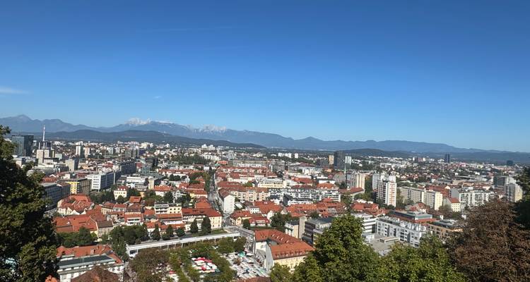 Panoramic view of a city with mountainous backdrop.