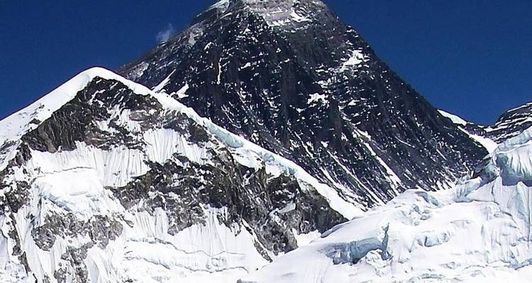 Snow-covered mountain peak with clear blue sky.