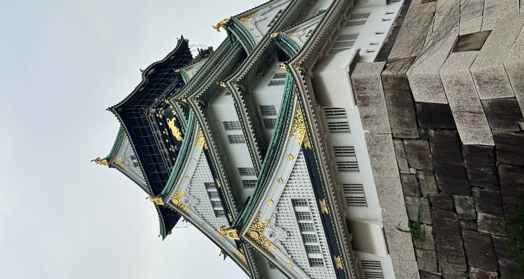 Osaka Castle rising against a cloudy sky.