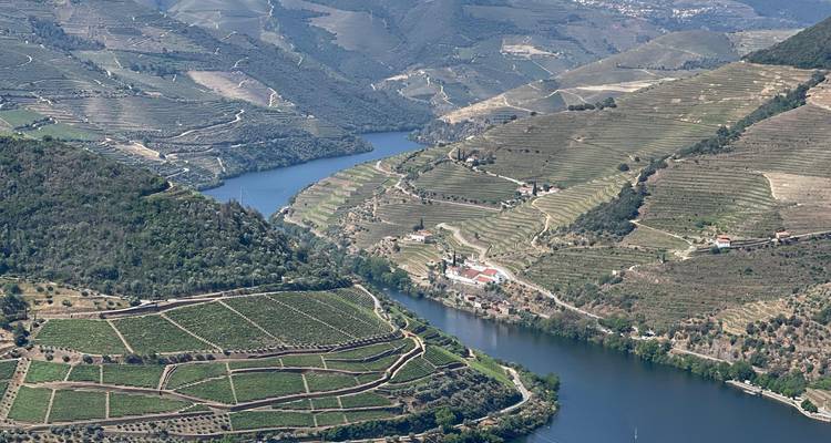 Aerial view of the Douro River running through terraced vineyards.