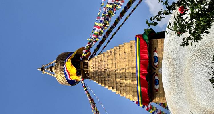 Stupa de Baudhanath avec drapeaux de prière contre le ciel bleu.