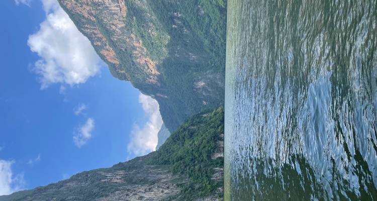River between steep cliffs under a clear sky.