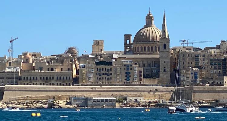 View of a fortified cityscape with a dome and spire.
