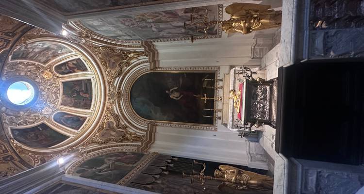 Un intérieur d'église orné avec des peintures religieuses et des accents dorés.
