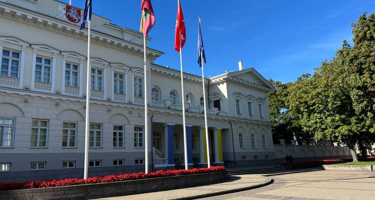Bâtiment gouvernemental avec des drapeaux sur fond de ciel dégagé.