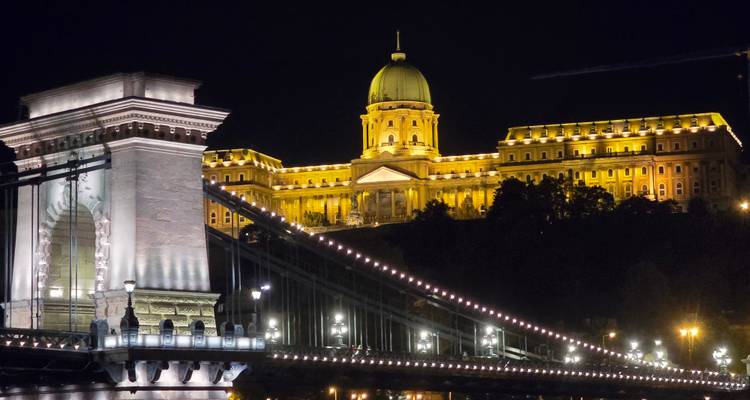 Un château et un pont magnifiquement éclairés la nuit.