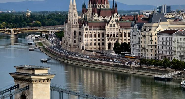 Vue panoramique de la ville incluant un bâtiment du parlement et une rivière.
