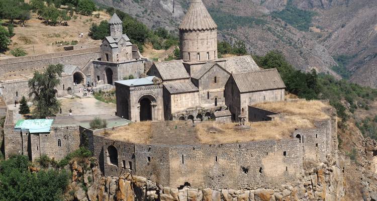 Monastère ancien sur une falaise entouré de montagnes