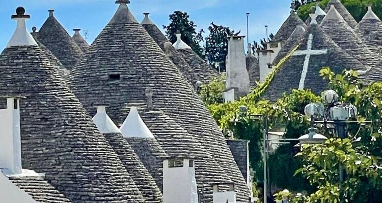 Vue rapprochée de maisons traditionnelles en pierre avec des toits coniques.