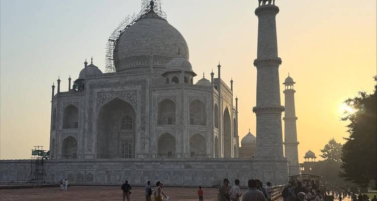 Le Taj Mahal à Agra, en Inde, au coucher du soleil avec des gens à proximité.