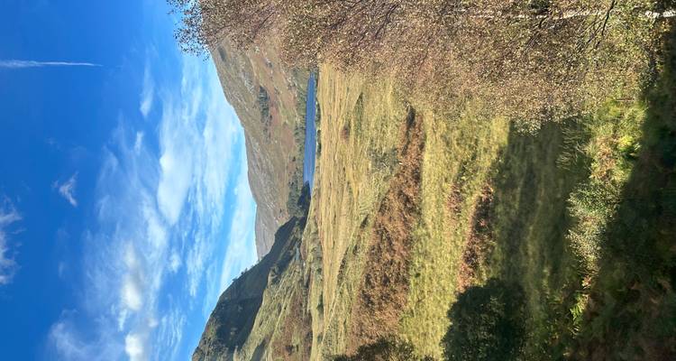 Un paysage vaste et ouvert avec des collines et un lac au loin.