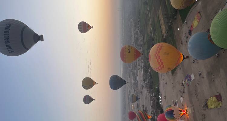 Hot air balloons floating over a landscape at dawn.