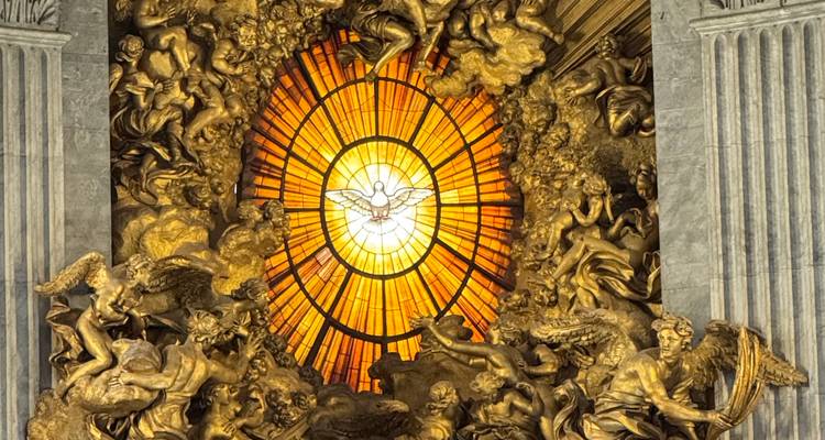 Intricate stained glass window with golden religious and ornamental designs.