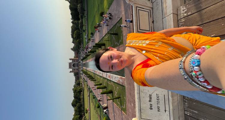 Femme en sari prenant un selfie avec le Taj Mahal.
