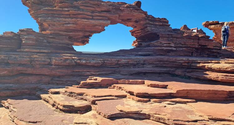 Formation rocheuse de grès rouge avec une ouverture d'arche naturelle.