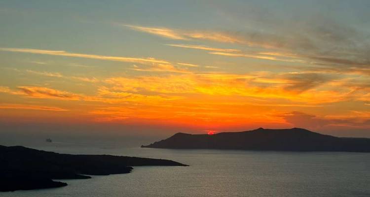 Vibrant sunset over the sea with silhouetted islands.