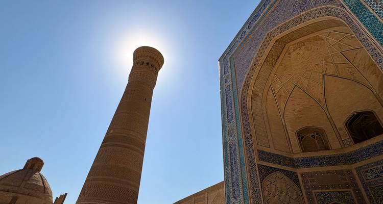 Silhouette d'un minaret contre un ciel lumineux.