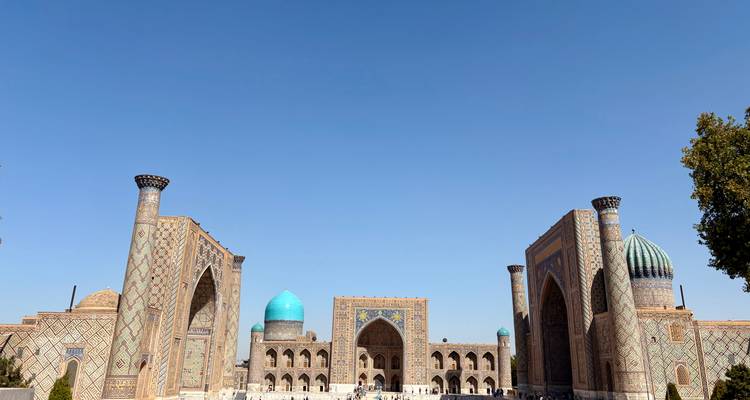 Vue panoramique d'une place historique animée avec des dômes bleus.