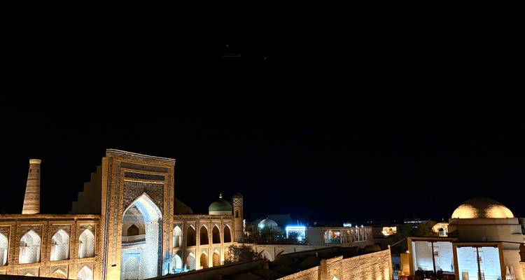 Vue nocturne de bâtiments historiques illuminés.