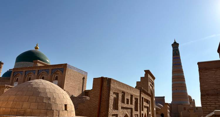 Oude stad met koepels en een hoge minaret.