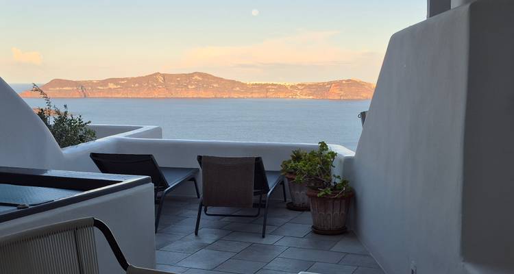 Patio de style méditerranéen avec chaises longues donnant sur la mer.