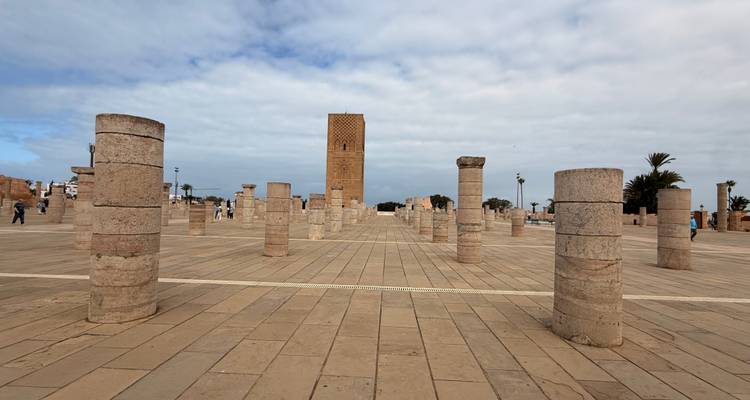 Tour Hassan parmi les ruines sous un ciel nuageux.