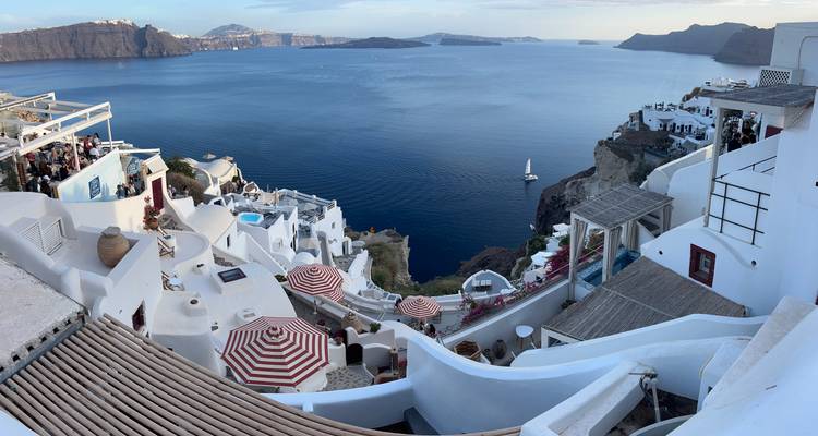 Vue panoramique de bâtiments blancs sur une falaise surplombant la mer.