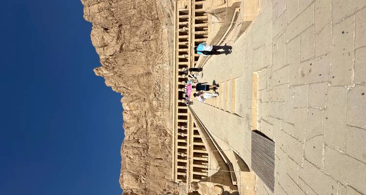 Tourists climbing the steps of an ancient Egyptian temple.