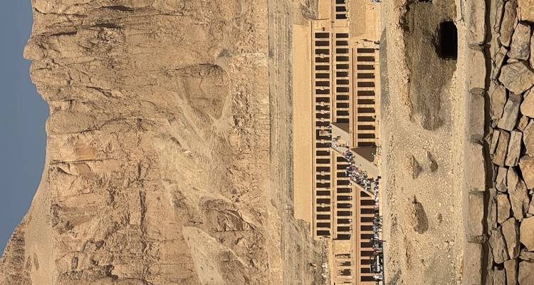 Une vue large d'un temple égyptien antique taillé dans une montagne.