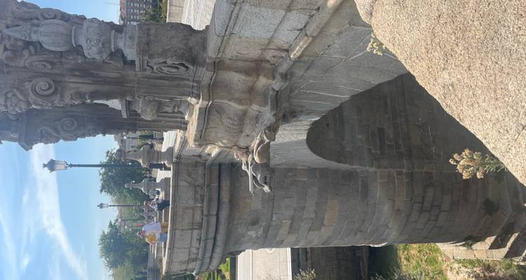 Pont de pierre avec des touristes sous un ciel bleu.