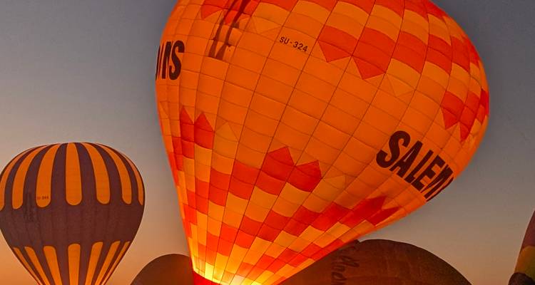 Hot air balloons rising during a clear sunrise or sunset.