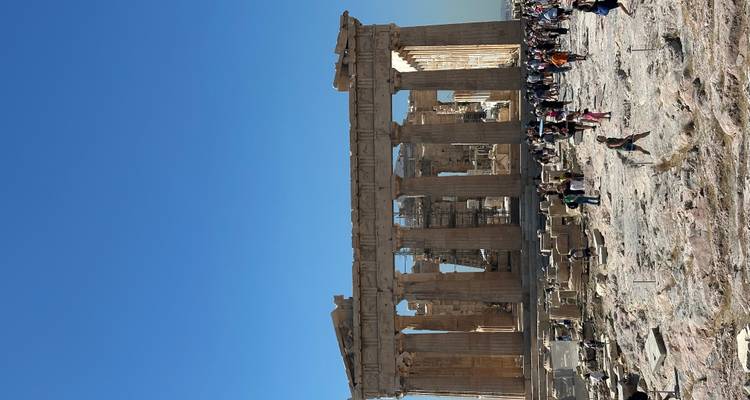 Tourists exploring the Parthenon ruins with clear blue sky.