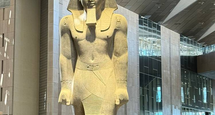 Statue d'un pharaon égyptien antique à l'intérieur d'un bâtiment moderne.