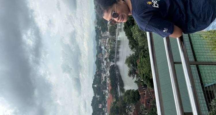 Person overlooking a lake with a scenic cityscape in the background.